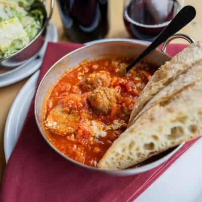 Italian meatballs in a hearty tomato sauce, served with sliced bread.
