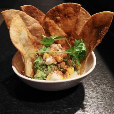 Guacamole served with crispy tortilla chips and garnished with cilantro.