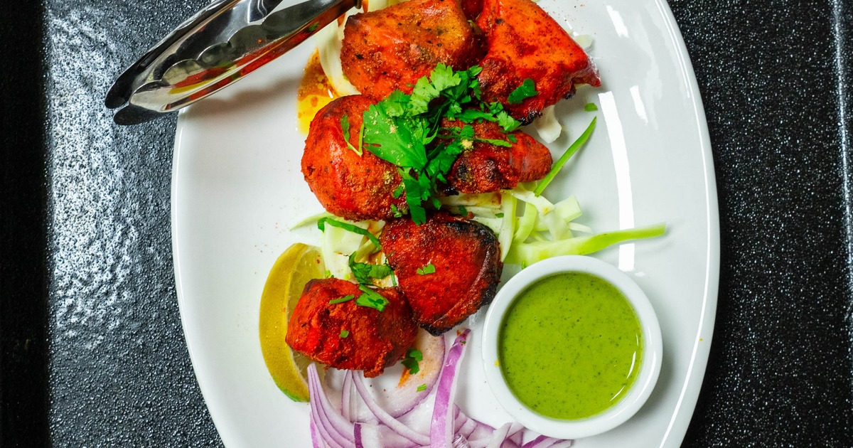Chicken Tikka served with sliced onion, lime wedge and a dipping sauce