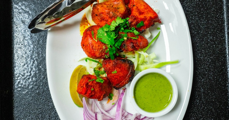 Chicken Tikka served with sliced onion, lime wedge and a dipping sauce