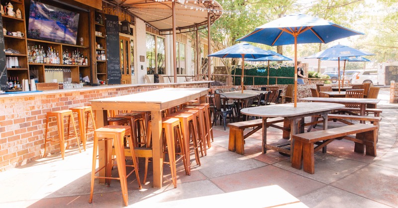 Exterior, partially covered seating area, bar table with stools, large outdoor bar on the left