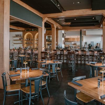 Dining area's interior with tables, chairs and brick wall bar.