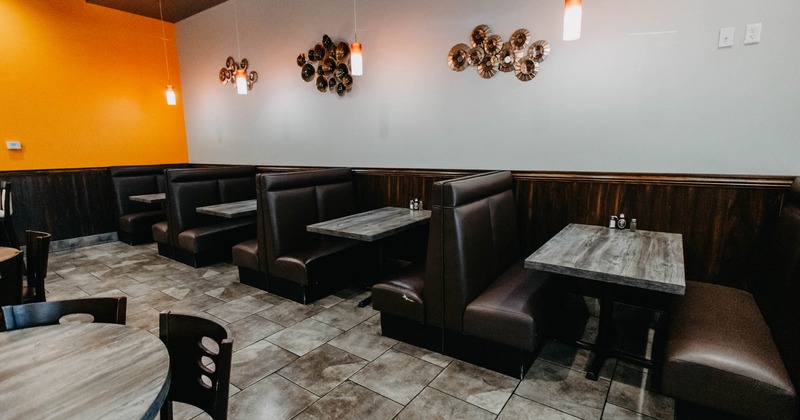 Interior, dining area, padded seating booths with tables, tile flooring, high hanging lanterns