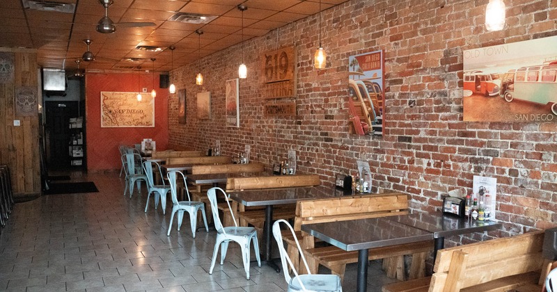 Interior, dining area, tile flooring, brick wall with posters, ceiling fans, back entrance