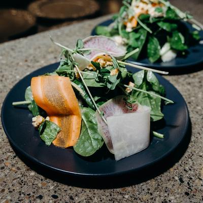 Spinach salad with carrots, radishes, and nuts.