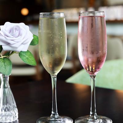 Glasses of Prosecco and Rosé stand next to floral display.