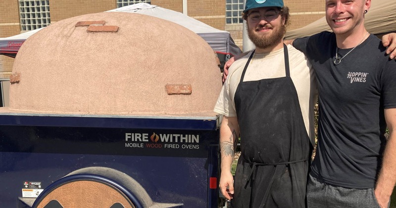 Staff members by the pizza oven