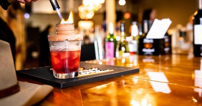 The bartender prepares a cocktail in the bar, a pleasant atmosphere behind