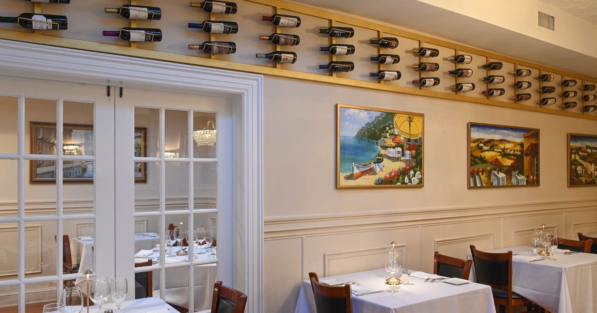 Interior of elegant and cozy dining area with dining tables along the wall set for two guests