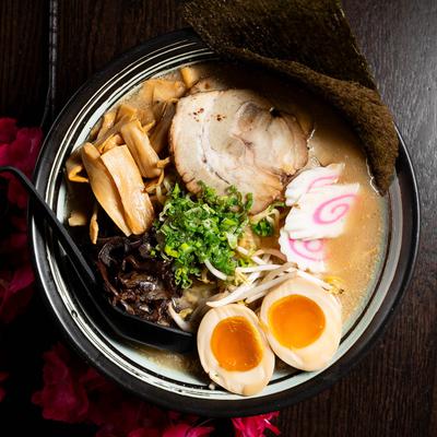 Tonkotsu ramen bowl with chashu pork, soft-boiled eggs, bamboo shoots, and seaweed.