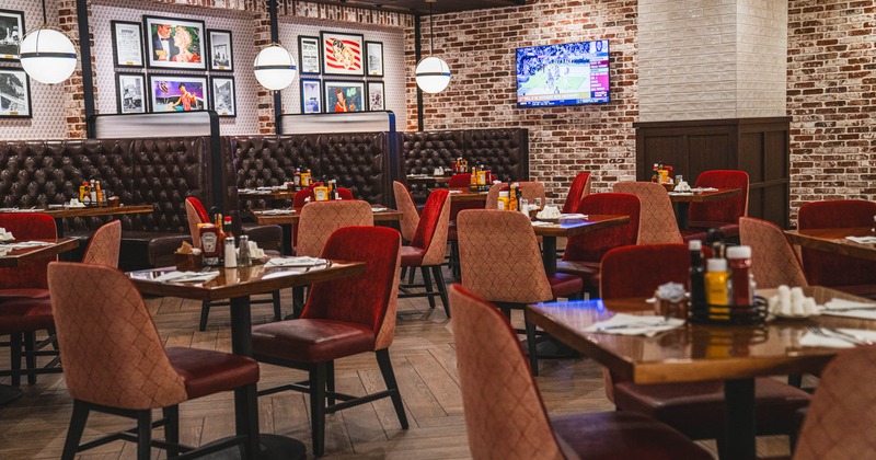 Interior, dining area, tables and chairs ready for guests, brick walls, various posters