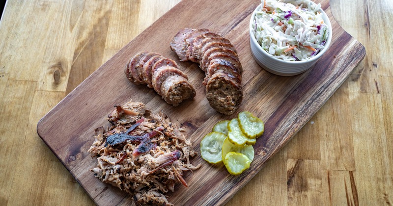 Meat platter with pulled pork, a sausage, and coleslaw