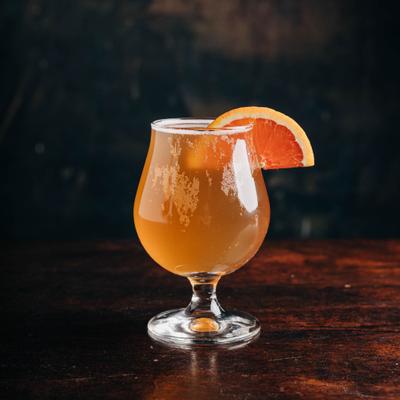 Lavender Orange Kombucha served in a glass with grapefruit garnish.