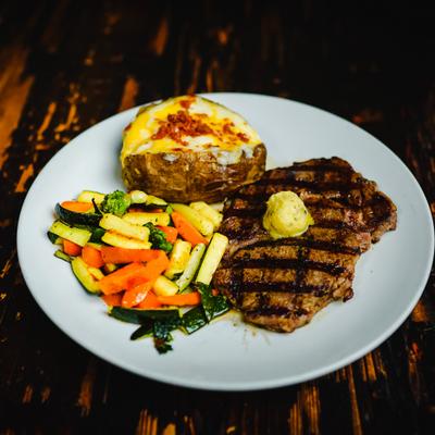 Steak with baked potato and garnish.