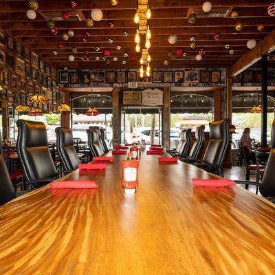 Interior with a long wooden table, black leather chairs, and festive ceiling decorations.