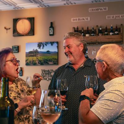 People sharing wine and conversation indoors.