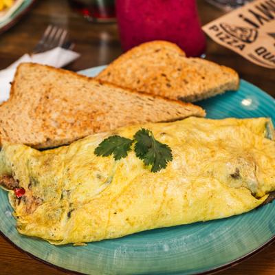 Pepper Bacon Sausage Omelette served with two slices of toast.