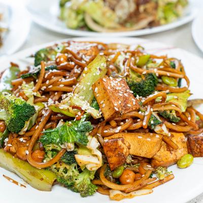 A plate of Stir fried noodles with vegetables and tofu.