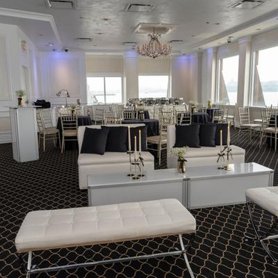 Elegant banquet room with white sofas and chandeliers.