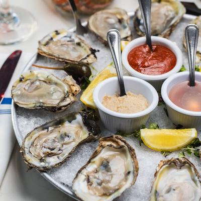 Oysters on a shell, served in an ice tray, top view, closeup.
