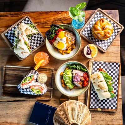 Assortment of food items served on the table with cocktails, overhead view.