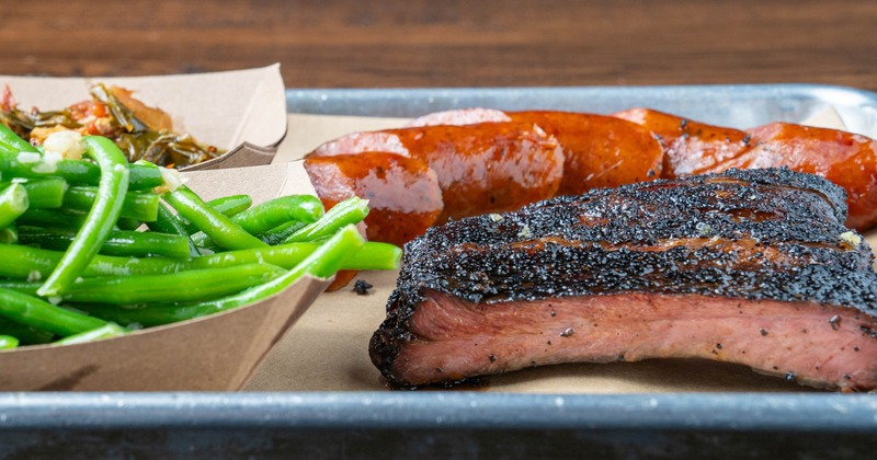 Smoked ribs and sausage link served with green beans and collards
