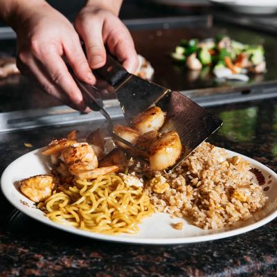Chef arranging food on the plate at Japanese grill table