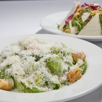 Caesar salad topped with grated cheese and croutons.