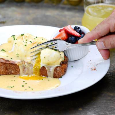 Eggs Benedict with Texas toast, and a small cup of fruit.