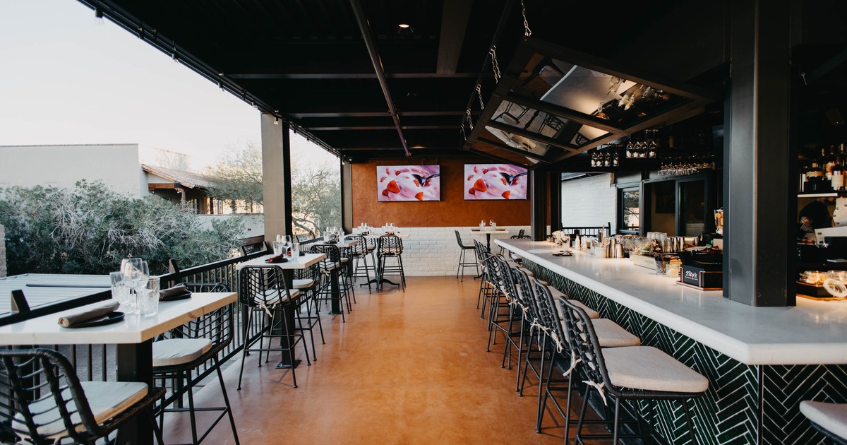 Modern open-air bar with high-top tables and counter seating