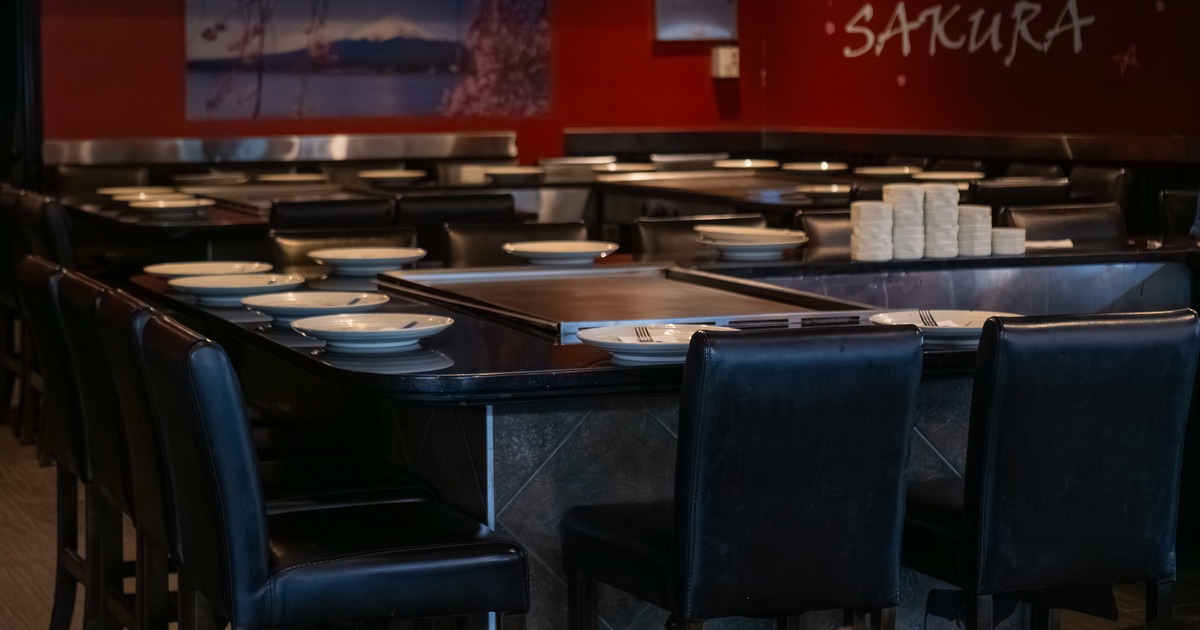 Large teppanyaki grill tables and black leather chairs
