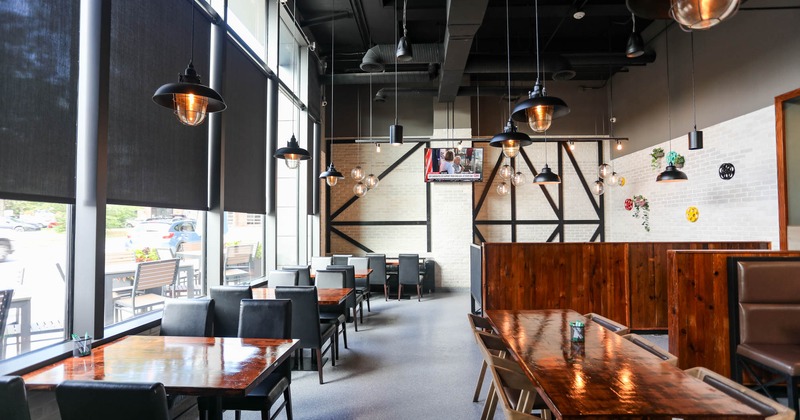 Interior, lined up tables and chairs by the windows