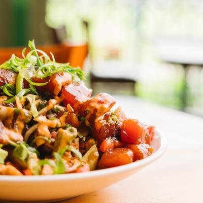 Poke nachos topped with sauce and greens.
