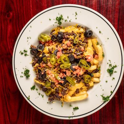 Nacho Fries topped with ground meat, olives, jalapenos, tomato and grated cheese.