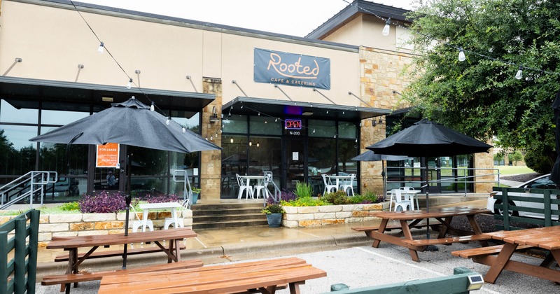 Exterior seating area with wooden picnic tables and umbrellas
