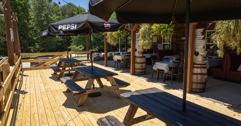 Outdoor dining area with wooden picnic tables and umbrellas