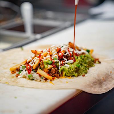 Bacon cheeseburger tortilla, with ground beef, rice, bacon, cheddar, guac, sour cream, and pico.
