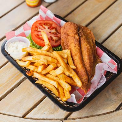 Fried fish sandwich served with fries and tartar sauce.