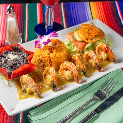 Shrimp with a side of black beans, rice, and vegetable salad.
