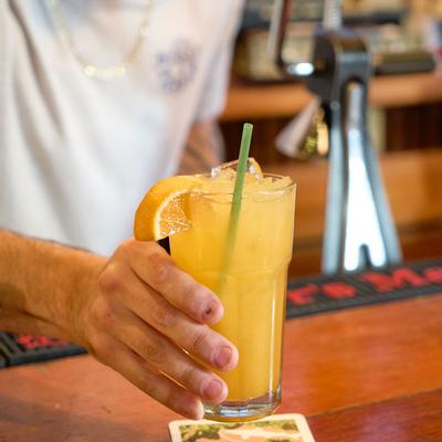 An employee serving orange juice