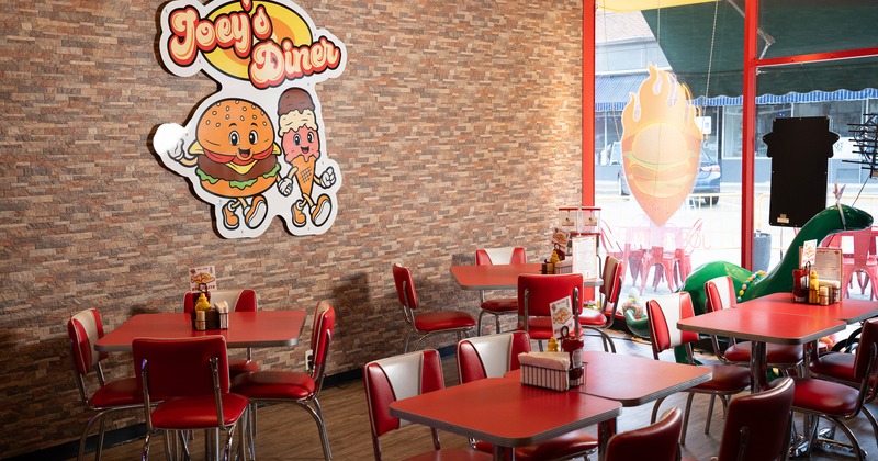 Interior of cozy dining area with red tables and chairs