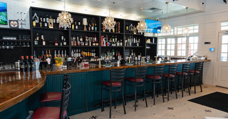 Interior, bar area, wooden top bar with stools, large over the wall drink shelves