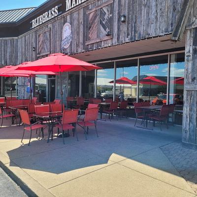 Outdoor seating area with red umbrellas, tables and chairs.