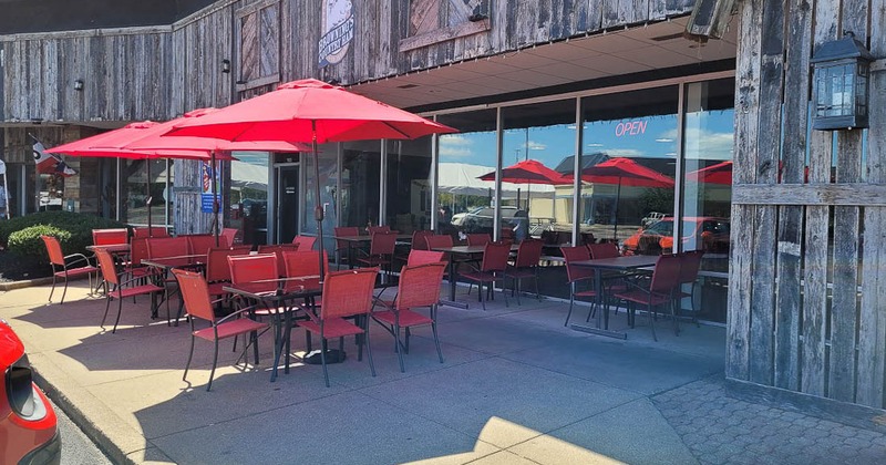 Outdoor seating area with red umbrellas, tables and chairs