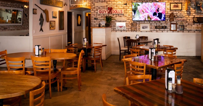 Inside, seating area with tables and chairs, TV on the wall
