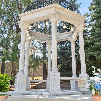 A white stone gazebo in a garden space