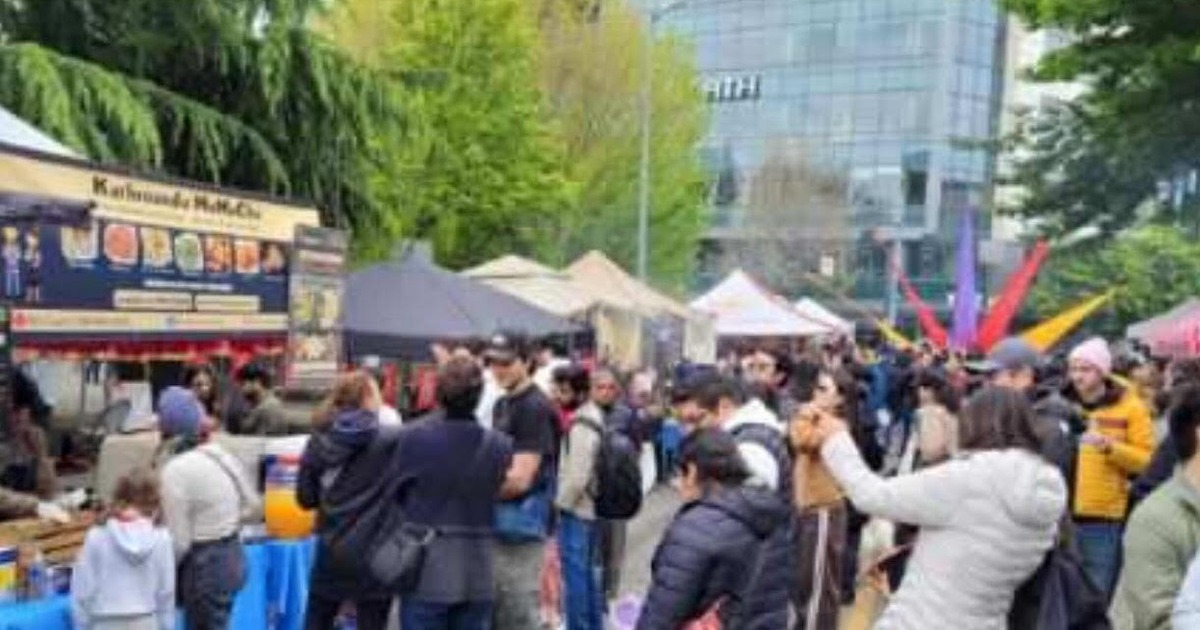 Outdoor crowd gathered near a vendor stand