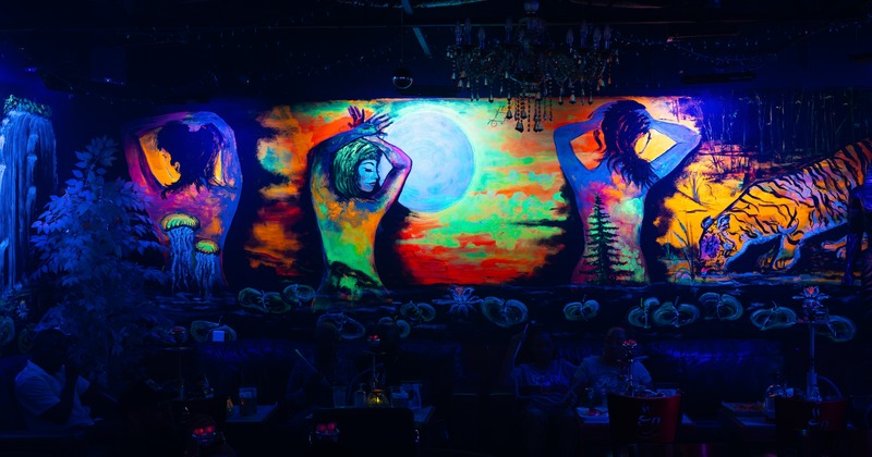 Darkness in the sitting area, fluorescent color drawing on the wall