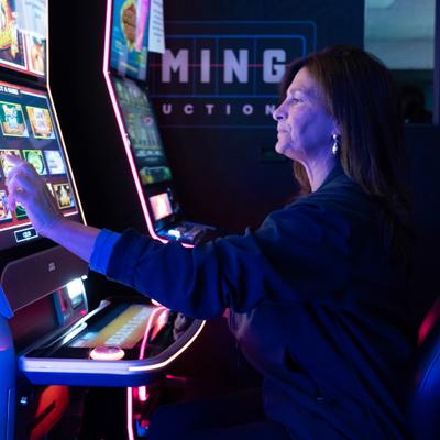 Side view of a person playing a slot machine.