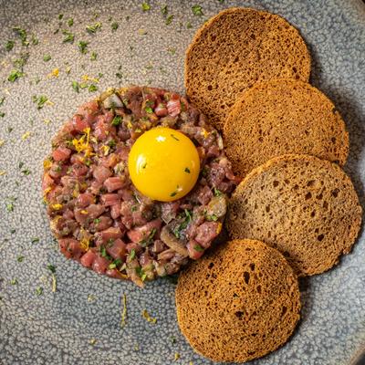 Steak tartare with raw egg yolk on top, top view